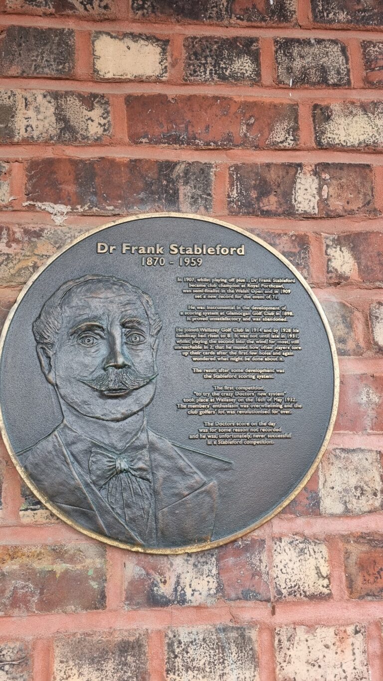 Bronze circular plaque on a brick wall honoring Dr Frank Stableford (1870–1959) with a portrait and biography text.
