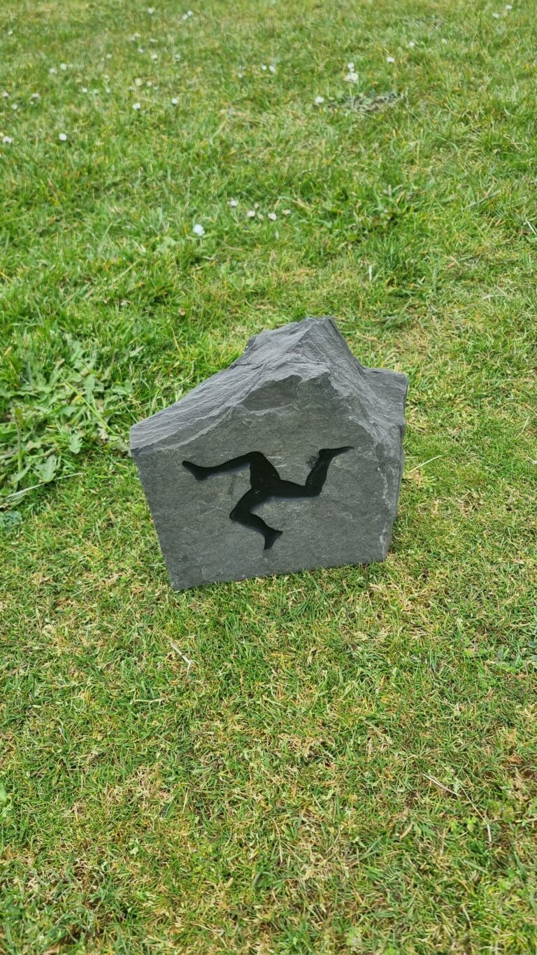 Gray stone block with a black silhouette of a person doing a backflip on grass